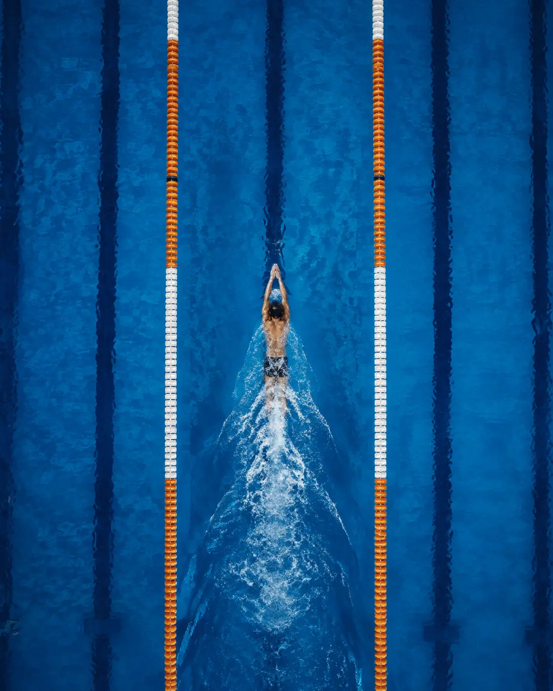 A swimmer moving down the exact center of a competition lane from above
